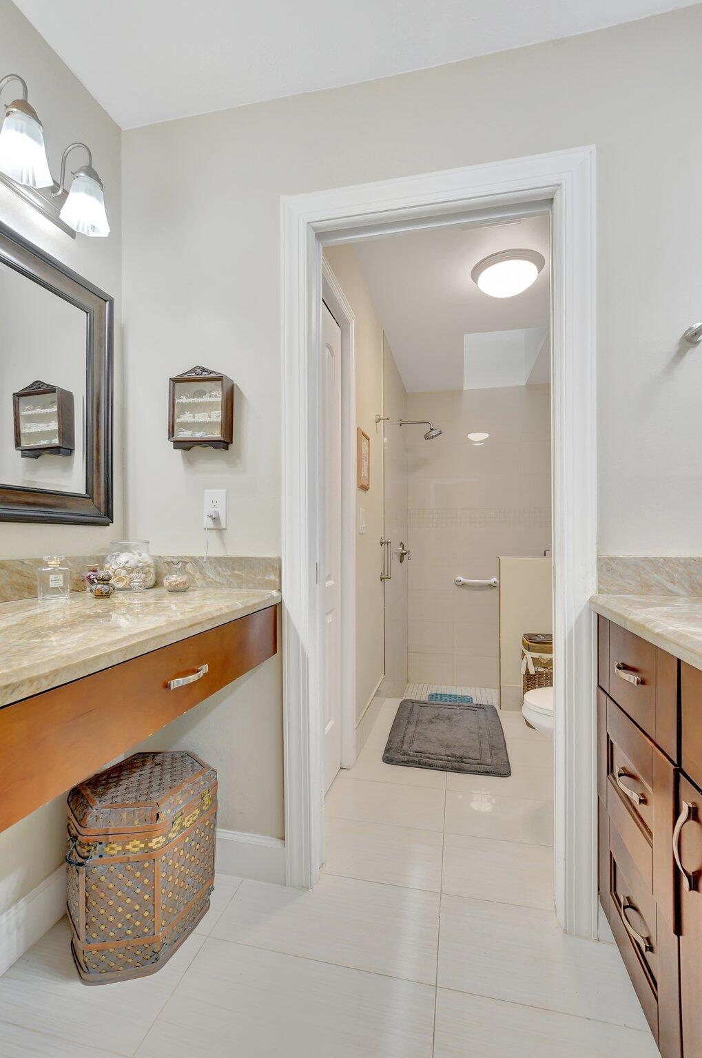 9717 Erica Court Boca Raton, FL 33496 - Photo 16 of 49 a spacious bathroom with a granite countertop sink and a mirror