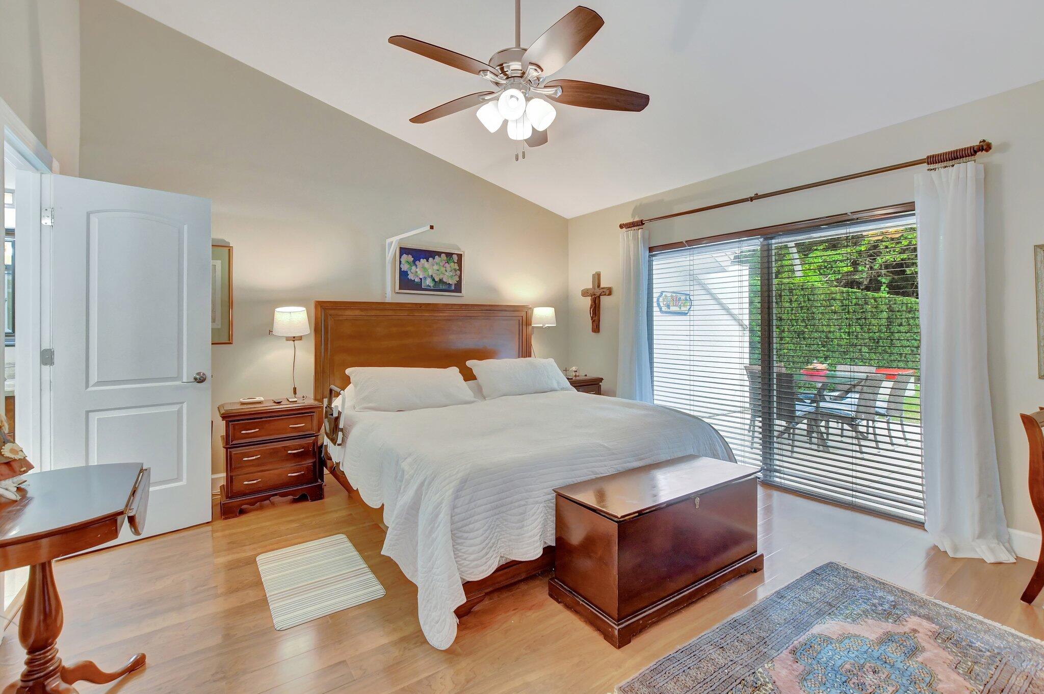 9717 Erica Court Boca Raton, FL 33496 - Photo 19 of 49 a bedroom with a bed lamp and a large window