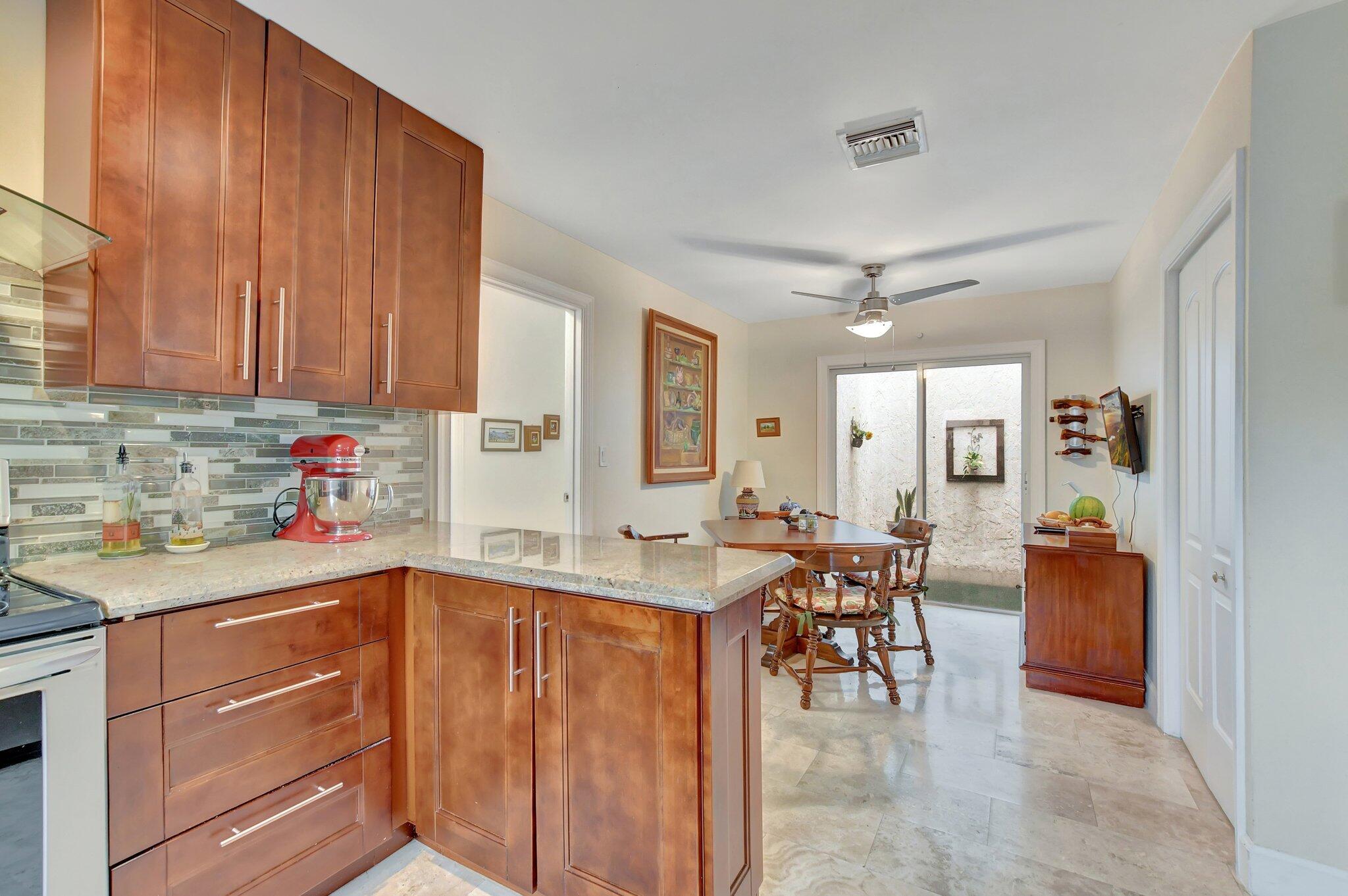 9717 Erica Court Boca Raton, FL 33496 - Photo 26 of 49 a kitchen with a sink refrigerator and cabinets