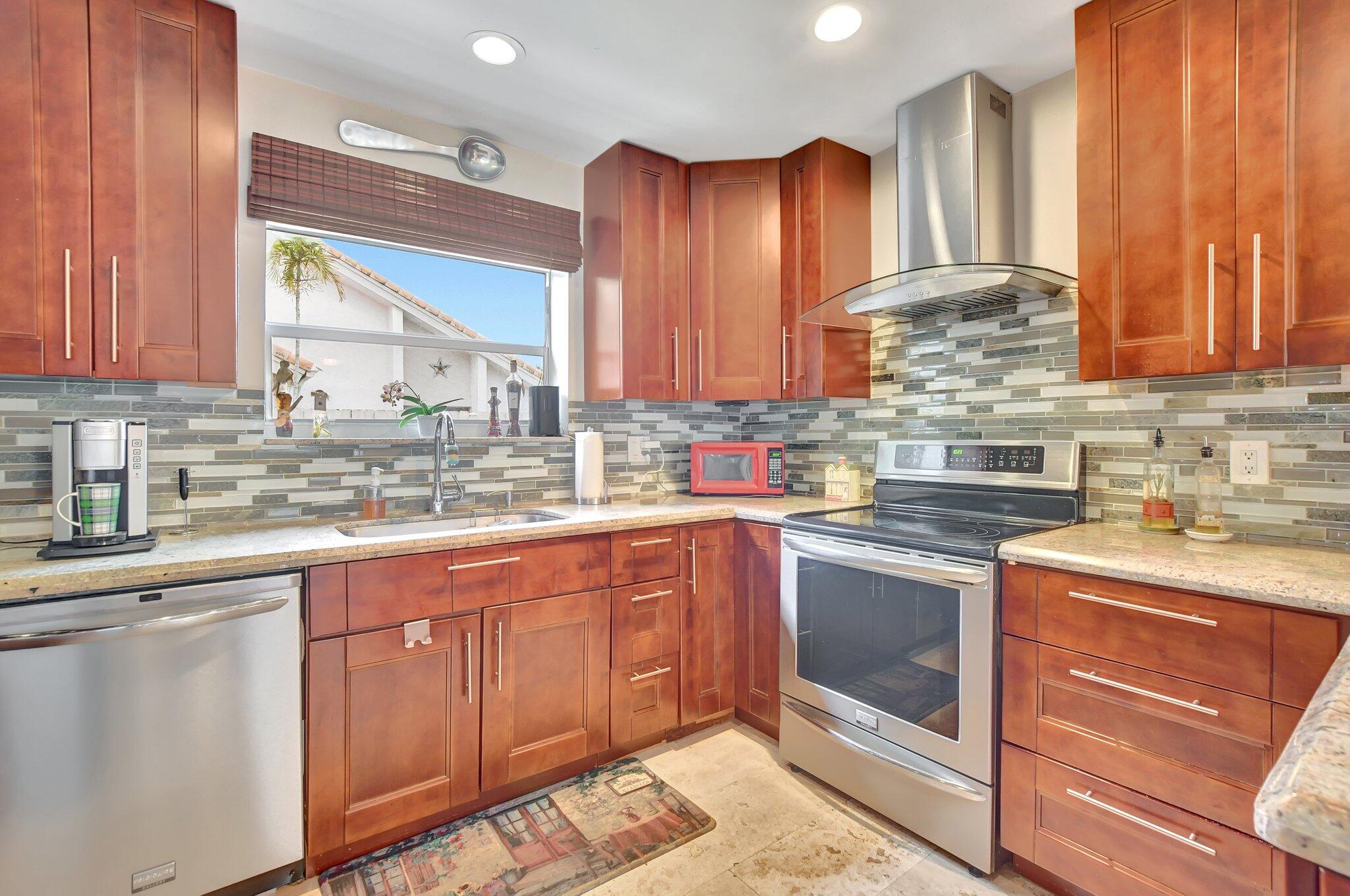 9717 Erica Court Boca Raton, FL 33496 - Photo 29 of 49 a kitchen with stainless steel appliances granite countertop a sink stove and cabinets
