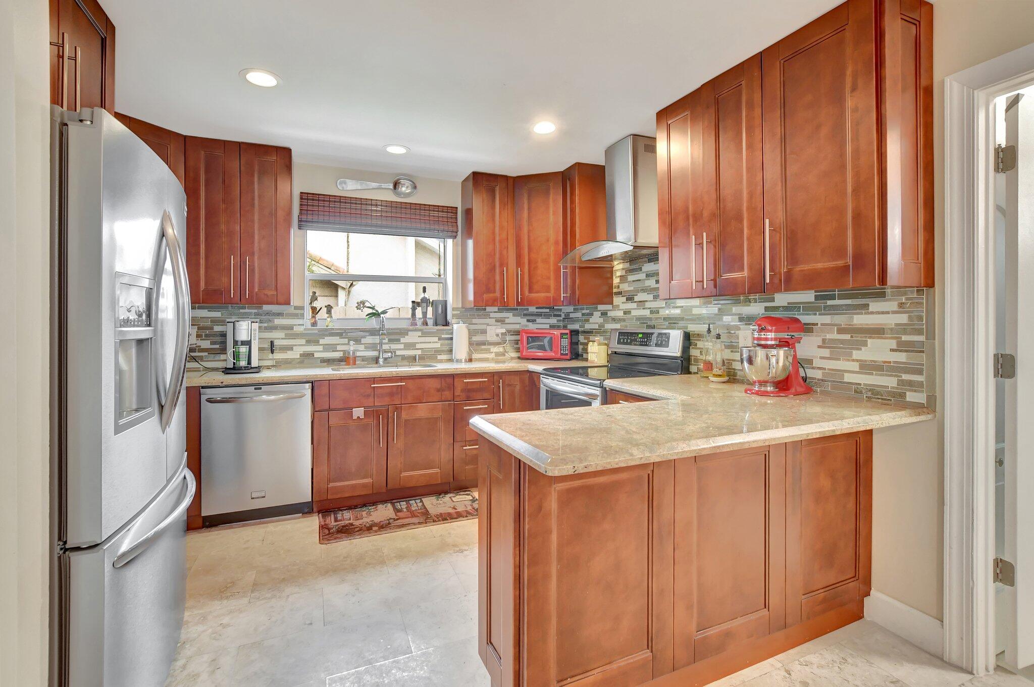 9717 Erica Court Boca Raton, FL 33496 - Photo 31 of 49 a kitchen with a sink window and cabinets