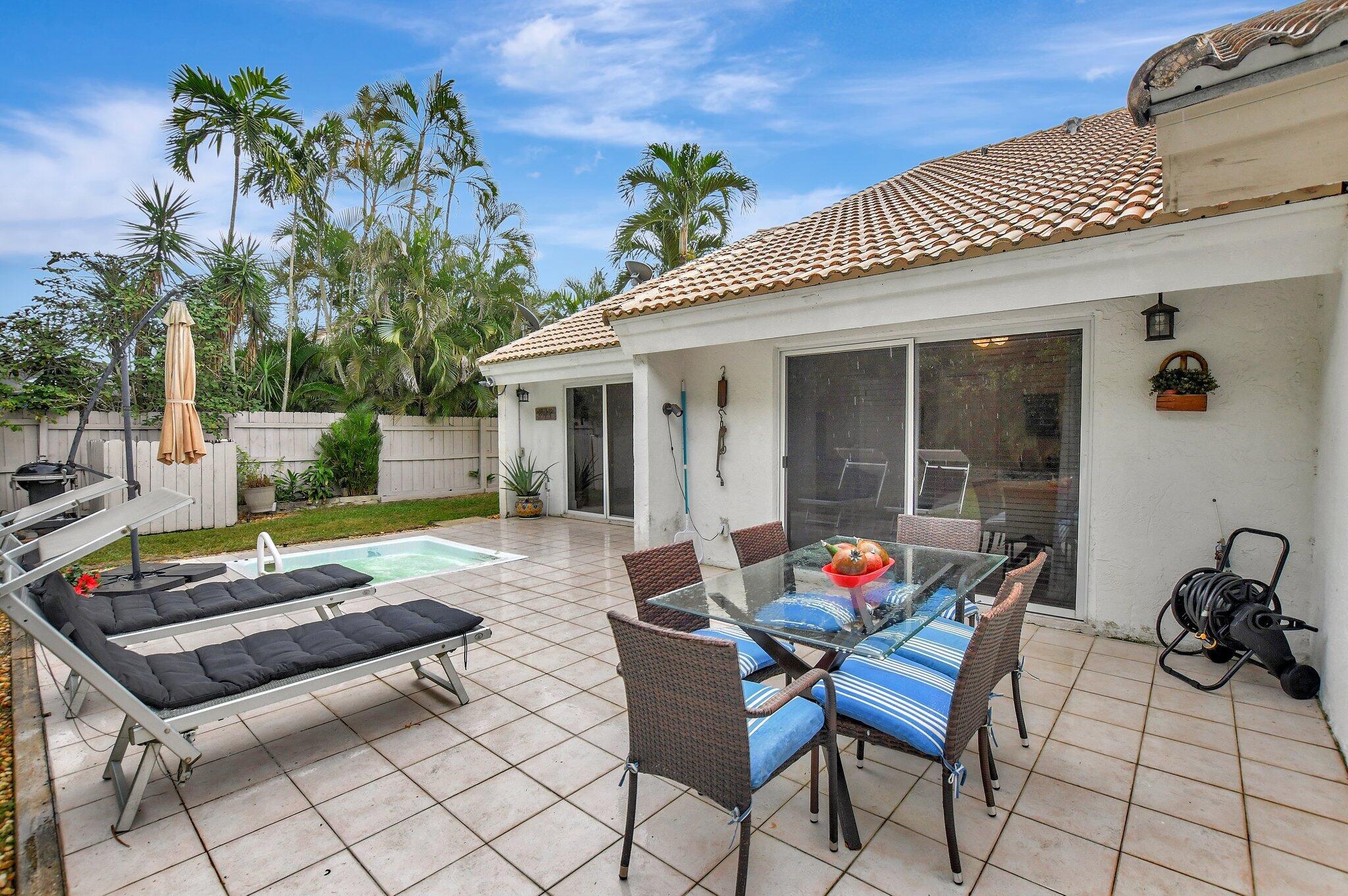 9717 Erica Court Boca Raton, FL 33496 - Photo 8 of 49 a backyard of a house with table and chairs