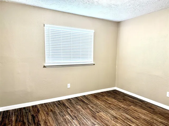a view of a room with wooden floor and a window