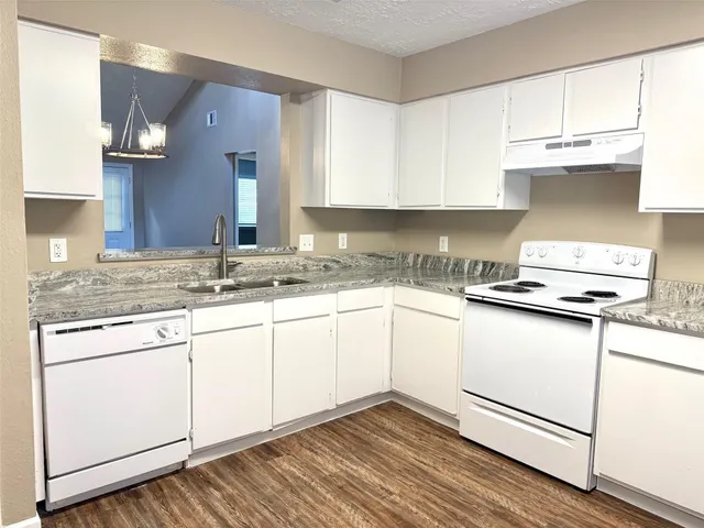 a kitchen with stainless steel appliances granite countertop a sink stove and cabinets