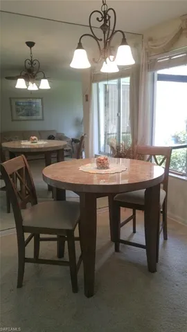 a dining room with wooden floor a chandelier a wooden table and chairs