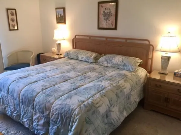 a bedroom with a bed and painting on the wall