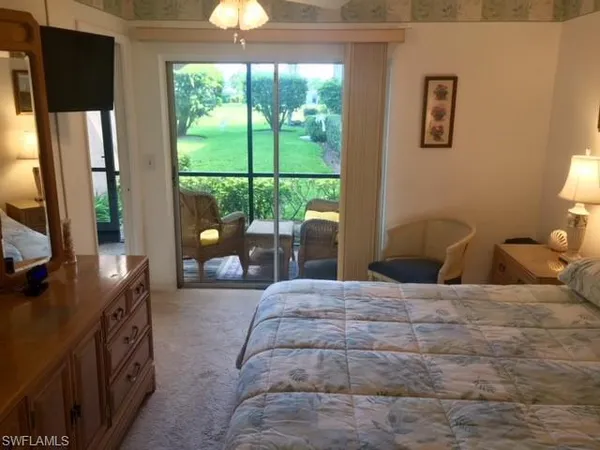 a bedroom with a balcony a bed and a flat tv screen on dresser