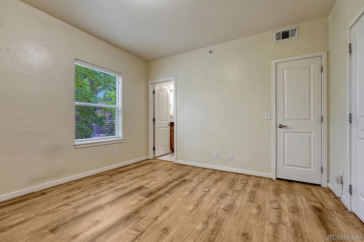 2389 South High Street, Unit 4 Denver, CO 80210 - Photo 15 of 27 a view of an empty room with wooden floor and a window