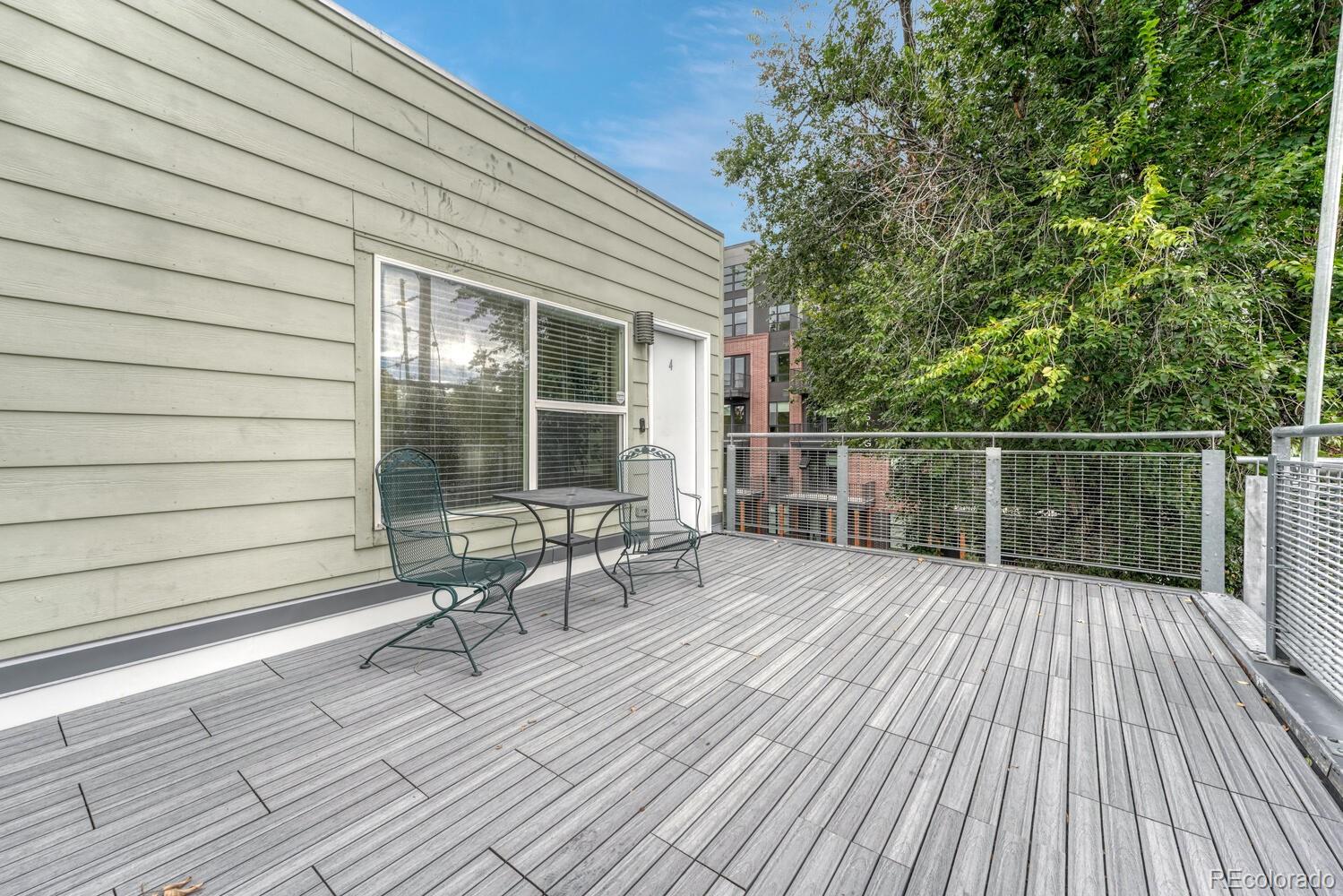 2389 South High Street, Unit 4 Denver, CO 80210 - Photo 17 of 27 a balcony with wooden floor table and chairs