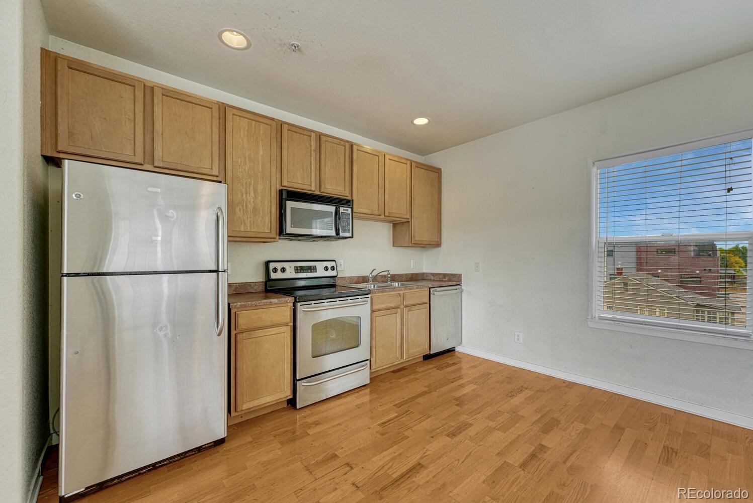 2389 South High Street, Unit 4 Denver, CO 80210 - Photo 5 of 27 a kitchen with a refrigerator a stove top oven a sink and dishwasher with wooden floor