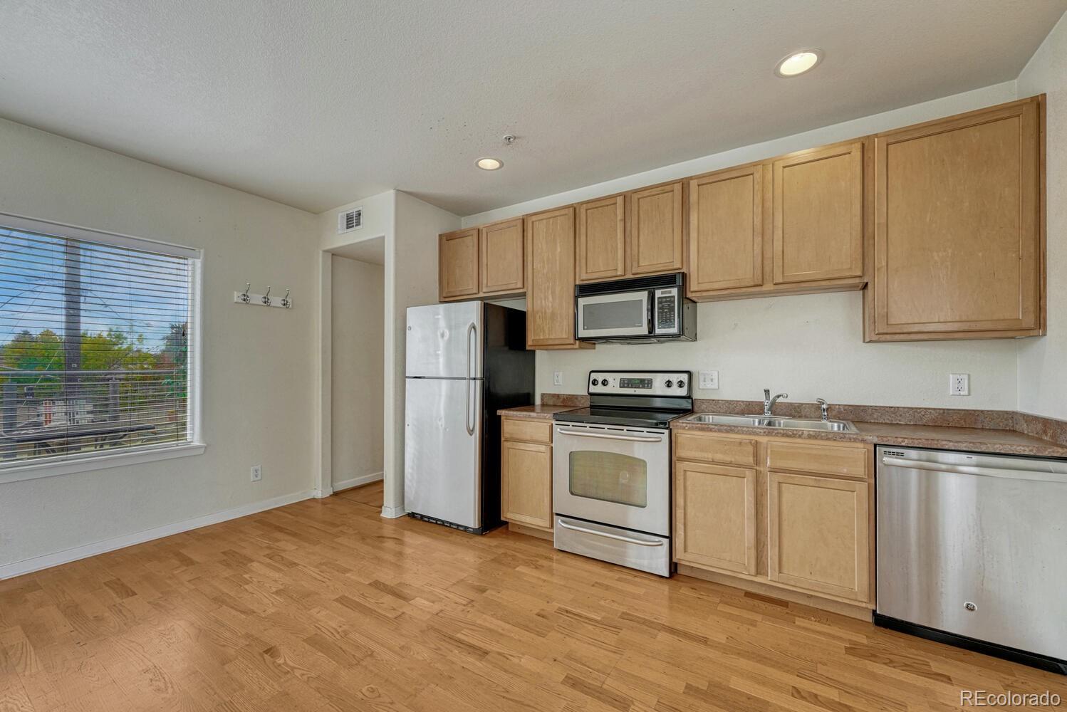 2389 South High Street, Unit 4 Denver, CO 80210 - Photo 7 of 27 a kitchen with a sink cabinets stainless steel appliances and a window