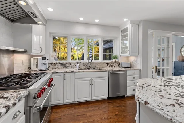 a kitchen with stainless steel appliances granite countertop a stove a sink and a refrigerator