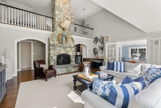 a living room with furniture a fireplace and a chandelier