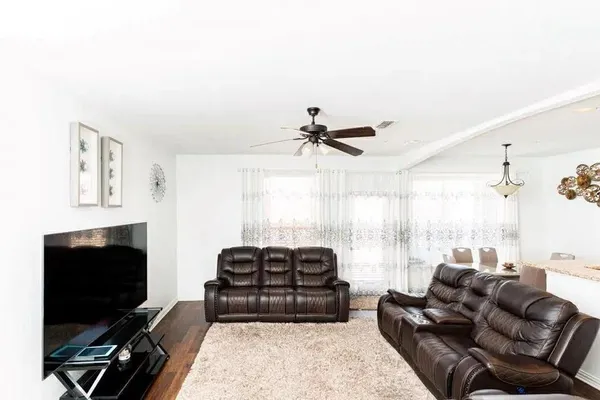 a living room with furniture a flat screen tv and a large window