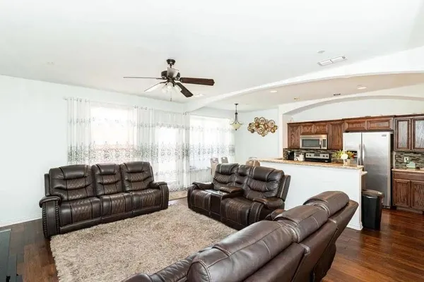 a living room with furniture ceiling fan and a window