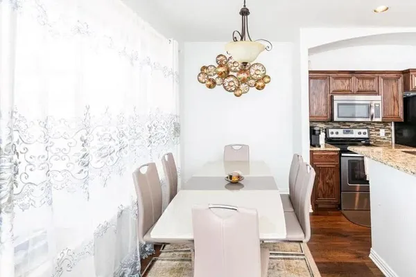 a dining room with furniture a chandelier and wooden floor