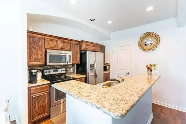 a kitchen with stainless steel appliances granite countertop a sink and refrigerator