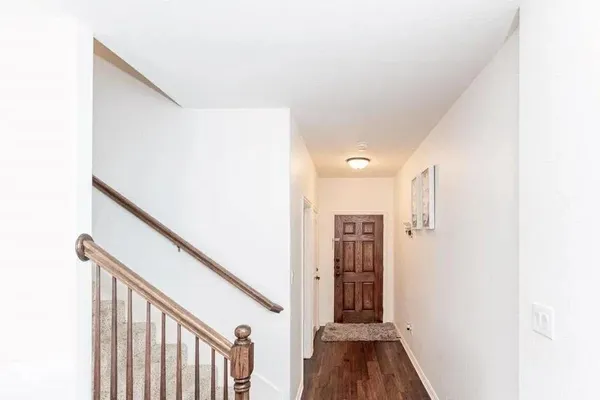 a view of hallway with stairs and wooden floor