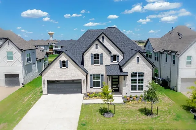 a front view of a house with a yard potted plants and chairs