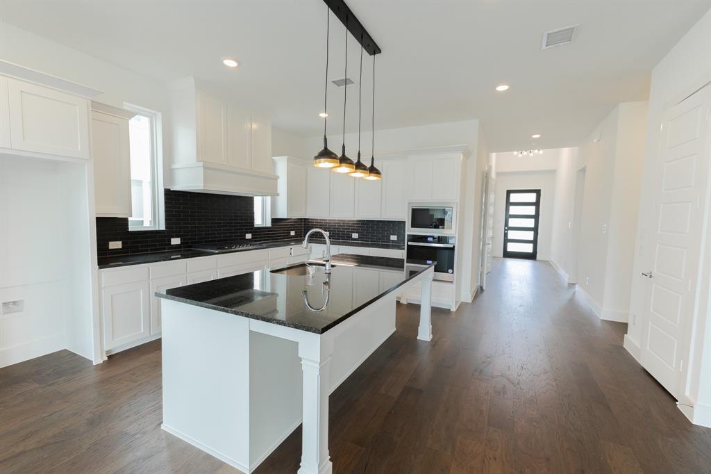 3020 Sunfish Street Prosper, TX 75078 - Photo 12 of 34 a kitchen with a sink a counter top space cabinets and stainless steel appliances