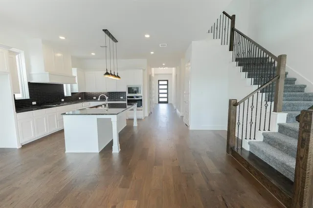 a view of a kitchen with cabinets stainless steel appliances and wooden floor
