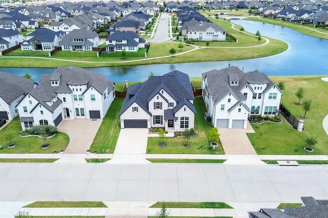 an aerial view of a house with a yard and lake view
