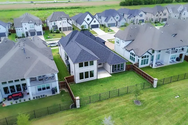 an aerial view of a house with swimming pool and a yard