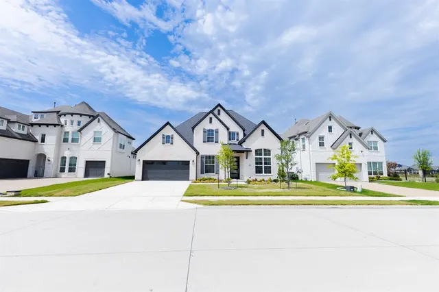 a front view of a house with a yard and trees