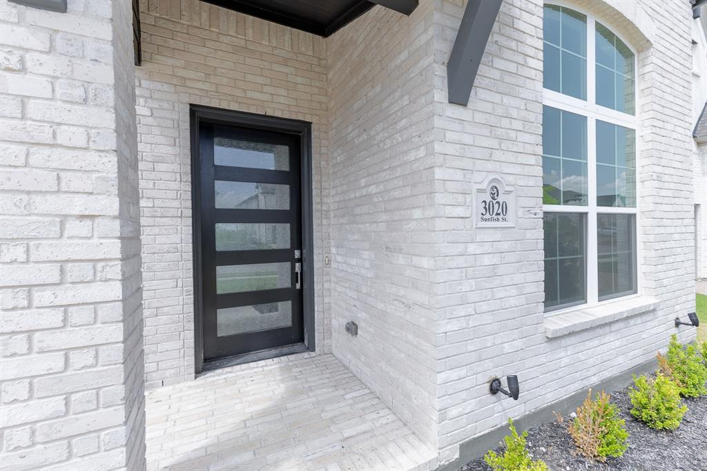 3020 Sunfish Street Prosper, TX 75078 - Photo 5 of 34 a view of a brick house with a large window