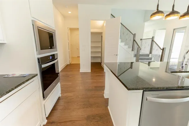 a kitchen with stainless steel appliances granite countertop a sink and a stove
