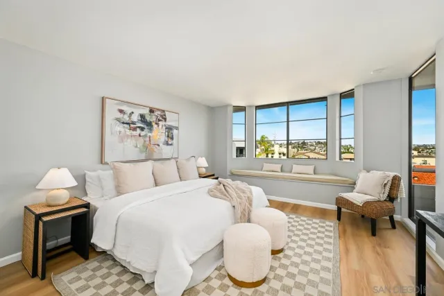 a spacious bedroom with a bed and glass windows
