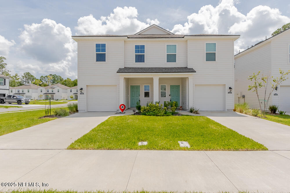 14438 Macadamia Lane Jacksonville, FL 32218 - Photo 1 of 32 a view of a white house with a yard potted plants and a table chair