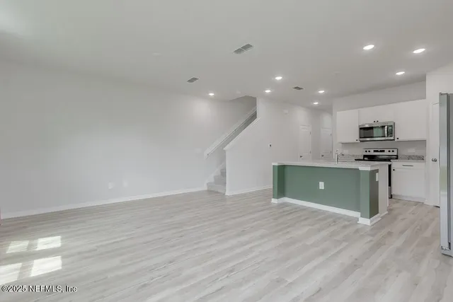 a view of kitchen with wooden floor and electronic appliances