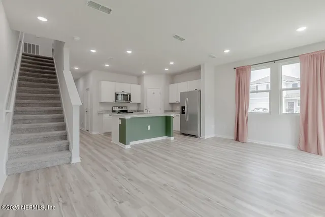 a view of kitchen with wooden floor and electronic appliances