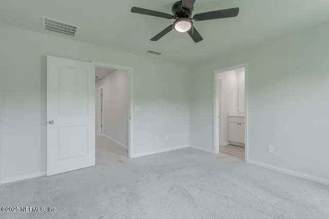 an empty room with closet and a chandelier fan