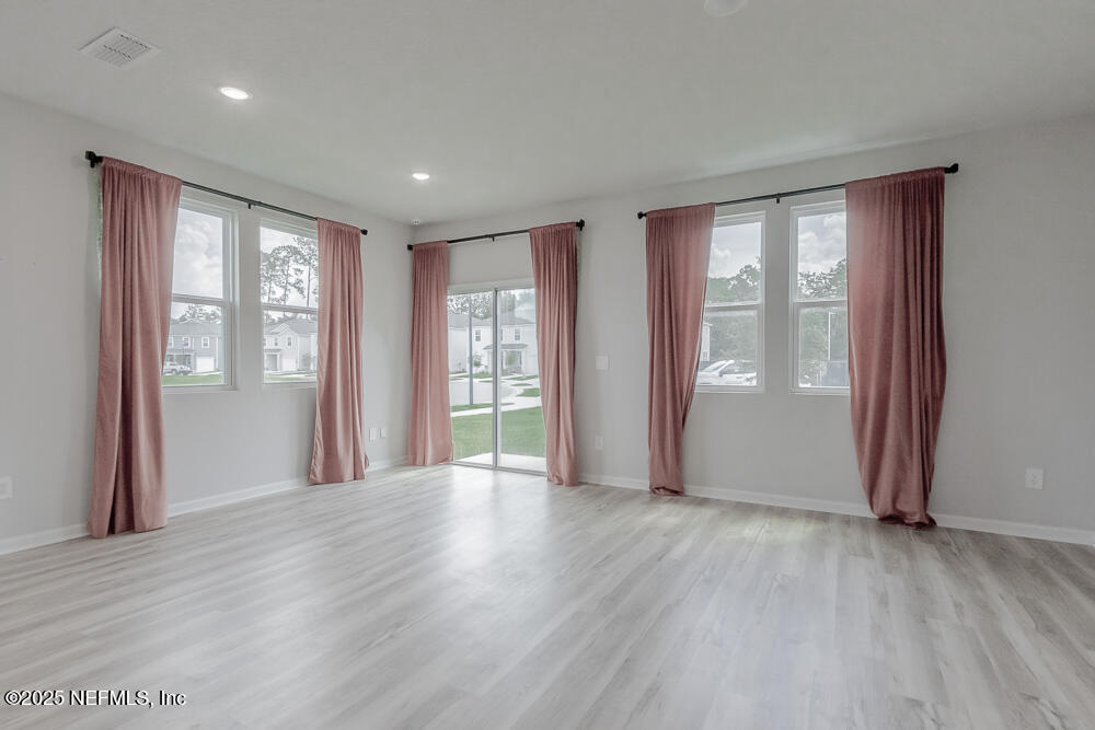 14438 Macadamia Lane Jacksonville, FL 32218 - Photo 3 of 32 a view of an empty room with wooden floor and a window