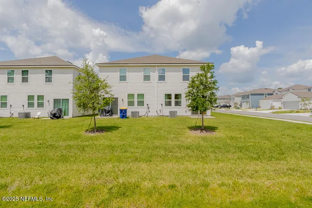 a view of a big yard with plants and large trees