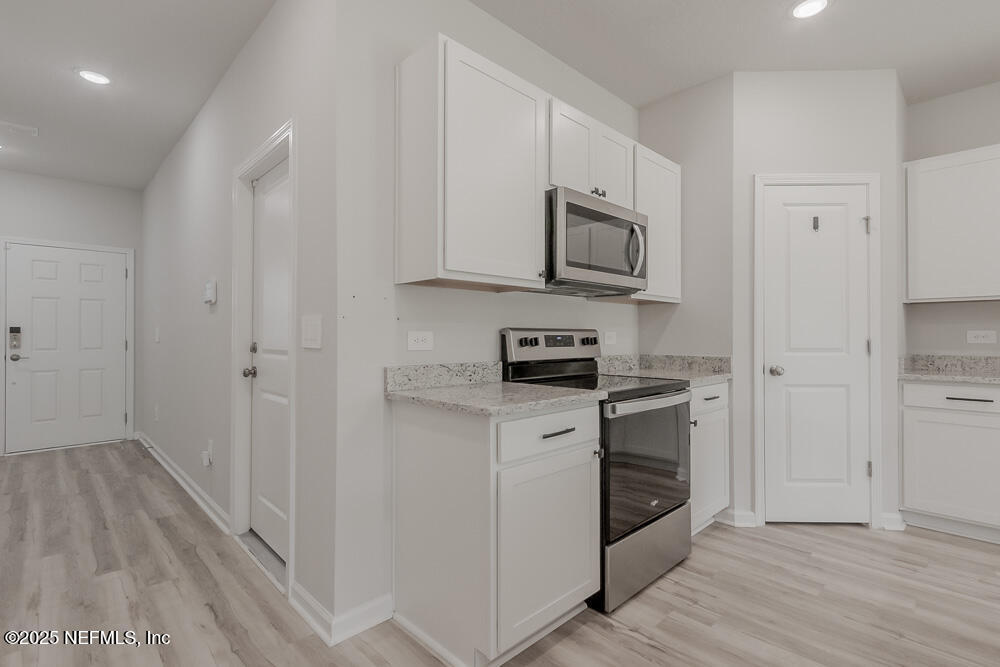 14438 Macadamia Lane Jacksonville, FL 32218 - Photo 8 of 32 a kitchen with stainless steel appliances granite countertop a stove a sink and a refrigerator