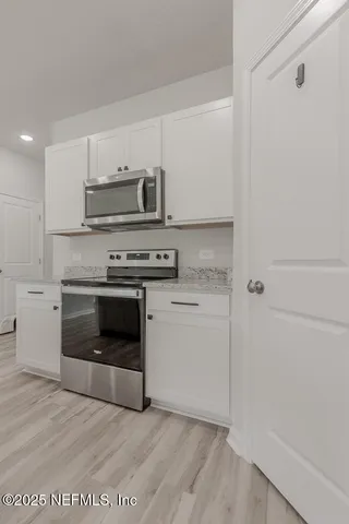 a kitchen with a stove top oven and cabinets