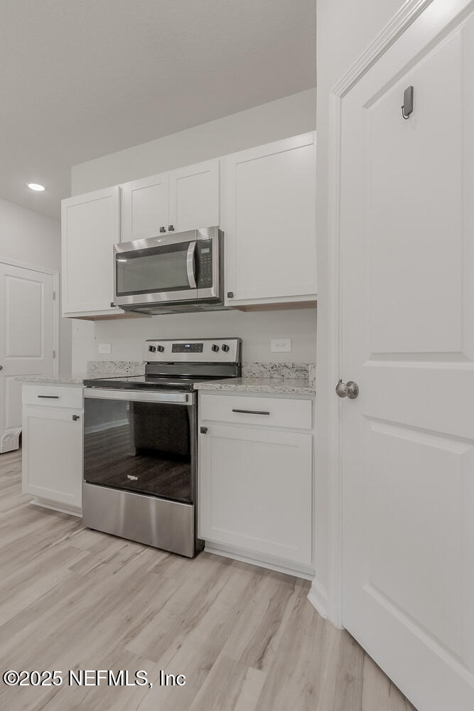 14438 Macadamia Lane Jacksonville, FL 32218 - Photo 9 of 32 a kitchen with a stove top oven and cabinets