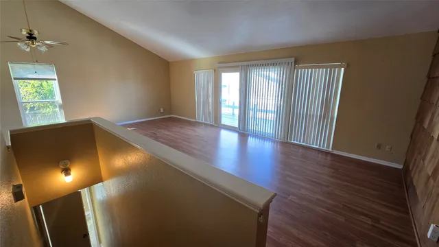 a view of a hallway with wooden floor and staircase