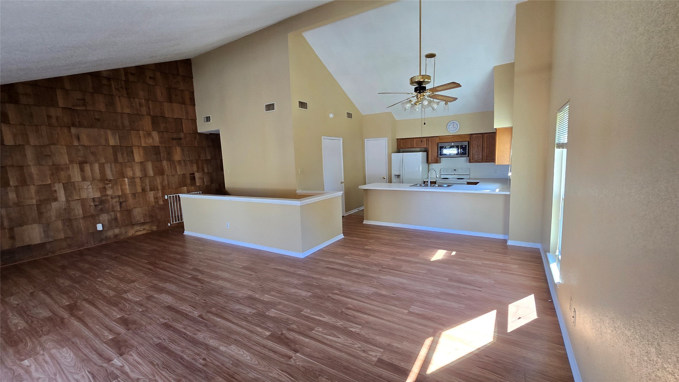 135 April Point Drive North Conroe, TX 77356 - Photo 18 of 28 a view of a kitchen with wooden floor and a ceiling fan