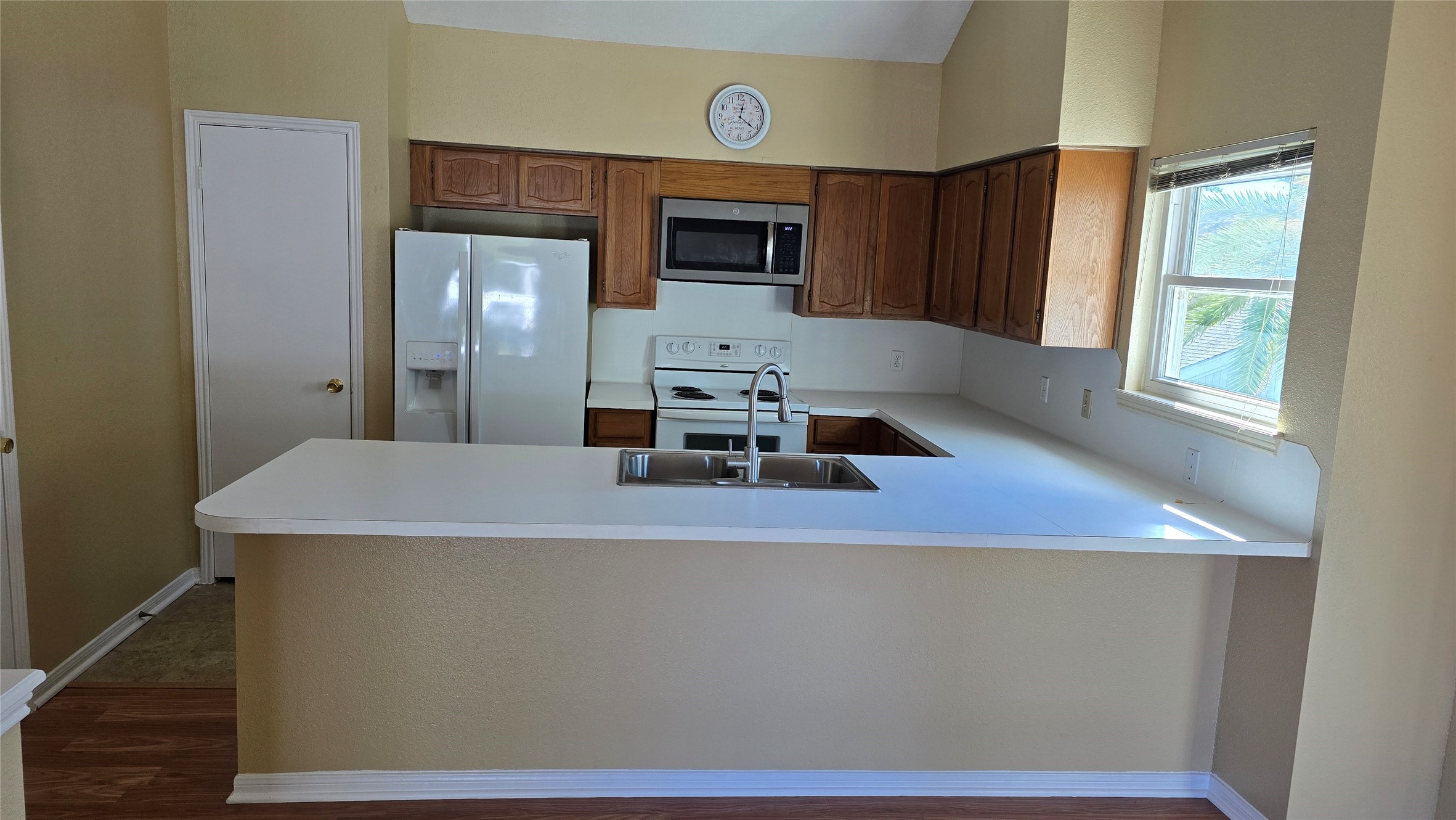 135 April Point Drive North Conroe, TX 77356 - Photo 19 of 28 a kitchen with kitchen island a sink wooden floor and a large window