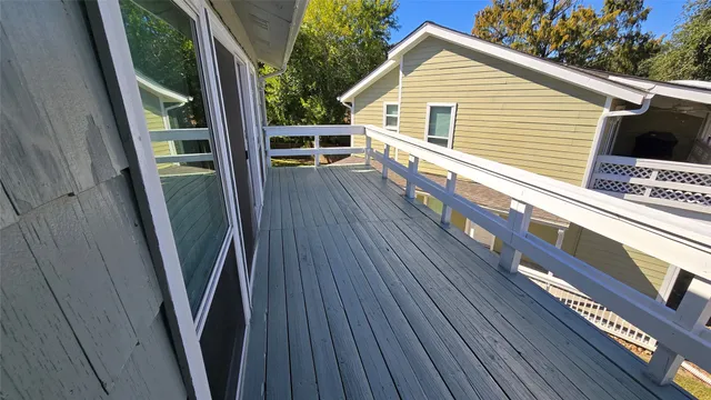a view of a balcony with wooden floor and fence