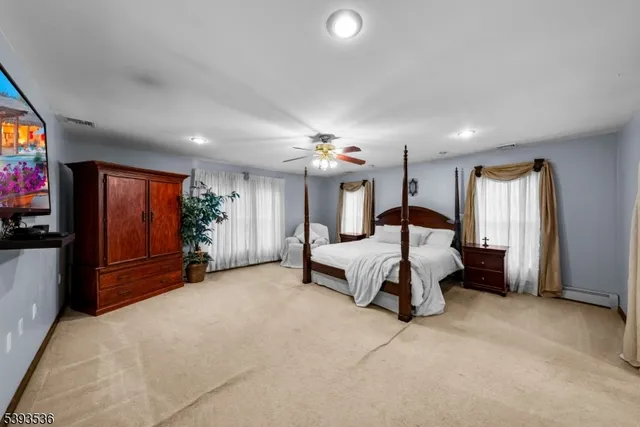a bedroom with a bed and a flat tv screen on dresser