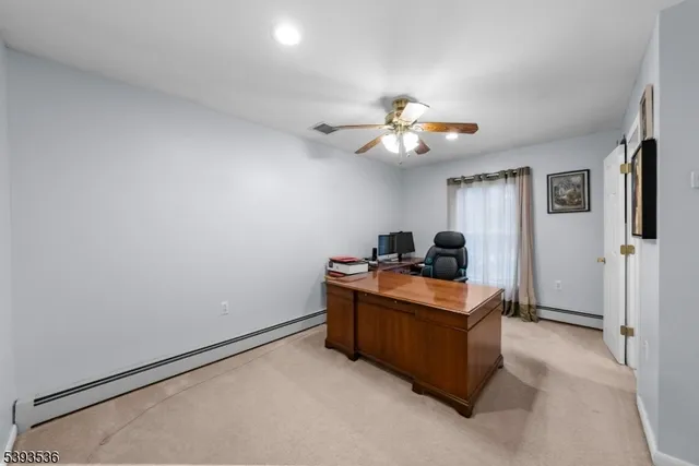 an empty room with chandelier fan and windows