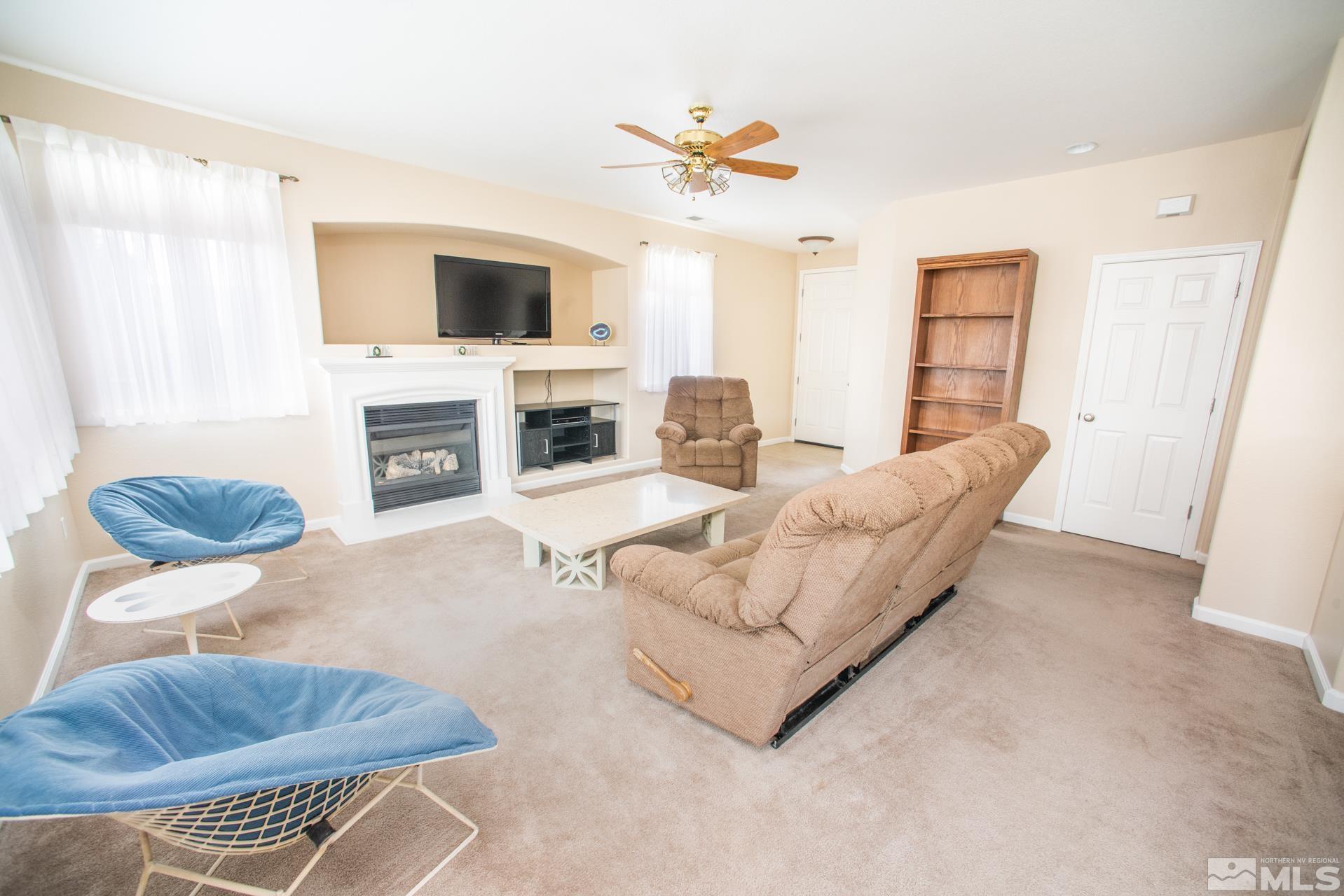 1798 Ornellaia Way Reno, NV 89521 - Photo 3 of 24 a living room with furniture a fireplace and a flat screen tv
