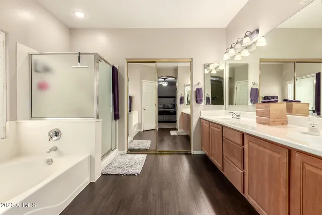 a bathroom with a granite countertop sink a large mirror and shower