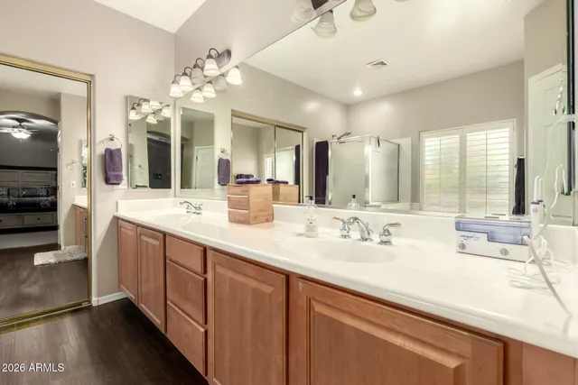 a bathroom with double vanity sinks a vanity a lamp and a mirror
