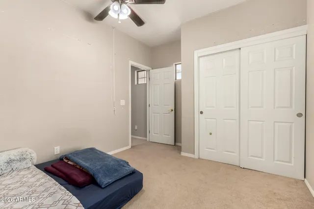 a living room with a bed and a ceiling fan